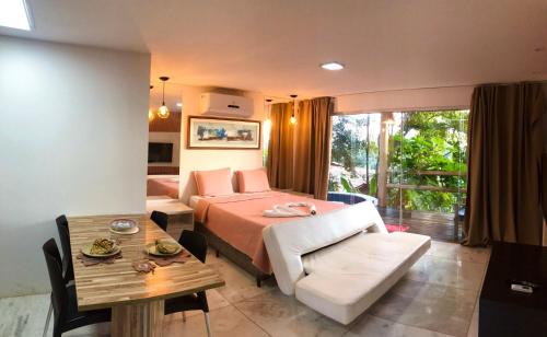 ein Hotelzimmer mit einem Bett und einem Tisch in der Unterkunft Bangalô Villas do Pratagy in Maceió