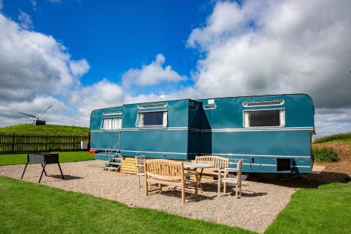 a blue trailer with a table and chairs at Middlemoor Farm Holidays in Alnwick
