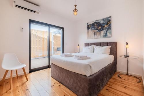a bedroom with a large bed and a chair at Azores Top House // Luxury and New House in Ponta Delgada