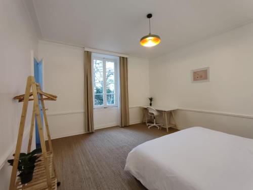 1 dormitorio con cama, escalera y ventana en Le manoir de la Plume 10min de Nantes centre ville, en Saint-Sébastien-sur-Loire