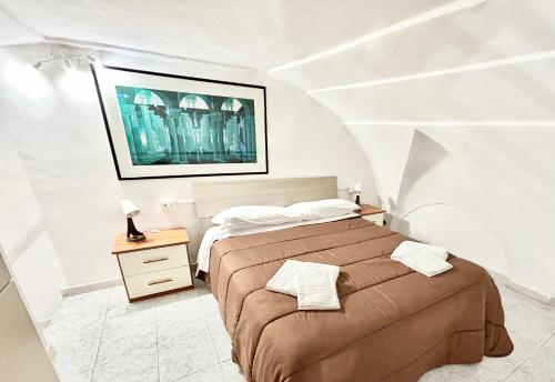 ein Schlafzimmer mit einem Bett und einem Nachttisch mit einem Bett von sidx sidx sidx sidx sidx in der Unterkunft Antico Borgo in Gaeta