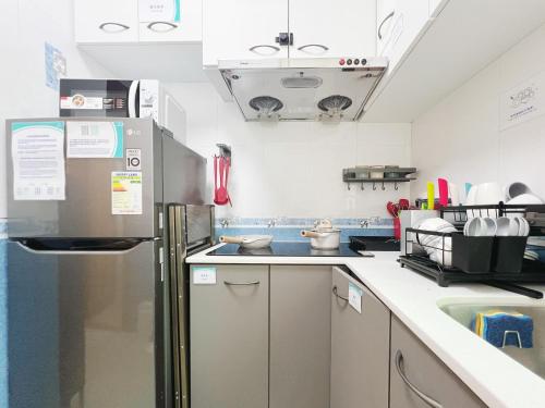 a kitchen with a refrigerator and a sink at Student Accommodation - 26 Man Yuen Street in Hong Kong
