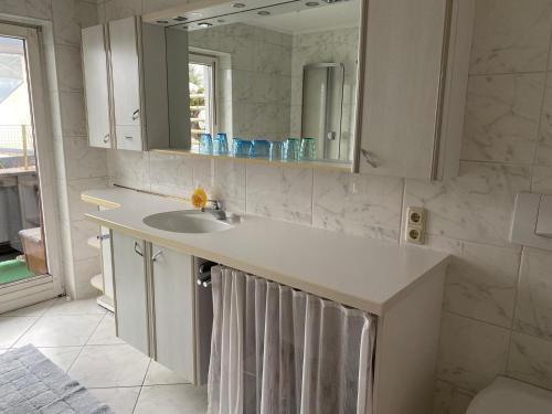 a white bathroom with a sink and a mirror at Haus Jochbergerstrasse 116 in Kitzbühel