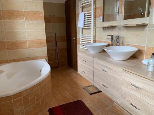 ein Badezimmer mit 2 Waschbecken und einer Badewanne in der Unterkunft Airport Road/Reptér közeli ház privát parkolóval in Budapest