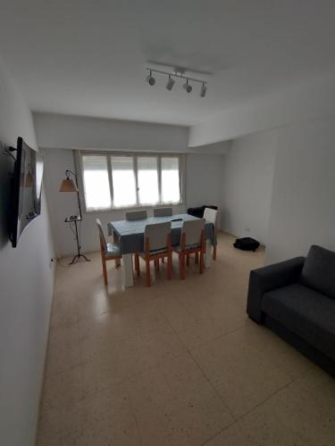 sala de estar con mesa, sillas y sofá en lobodemar2 en Mar del Plata