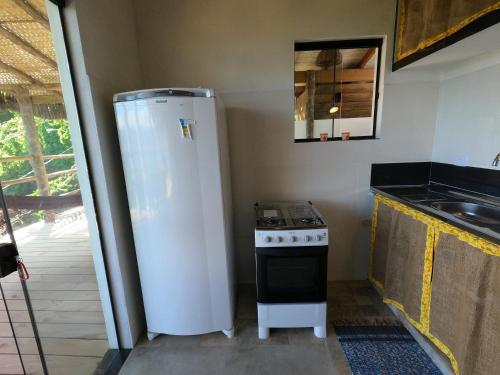 a kitchen with a white refrigerator and a stove at Villa Girassol in Ilhabela