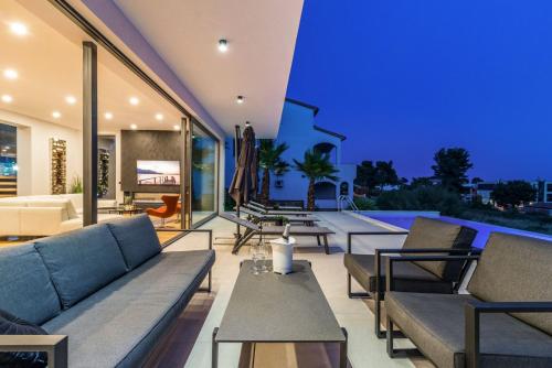 a living room with couches and a pool at Luxury TABOO Villa & Spa in Medulin for 8 people with heated pool- wellness & sea view in Medulin