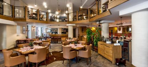 ein Restaurant mit Tischen und Stühlen und eine Bar in der Unterkunft Hotel Silvia Gold Gliwice in Gliwice