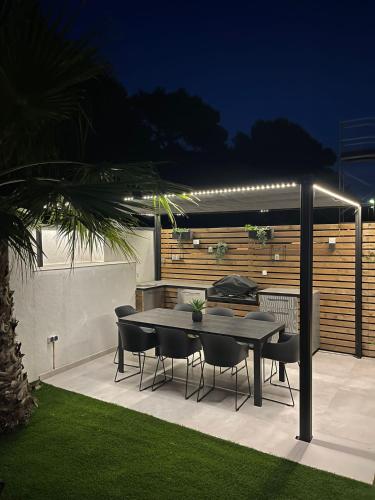 a table and chairs on a patio at night at Luxury TABOO Villa & Spa in Medulin for 8 people with heated pool- wellness & sea view in Medulin