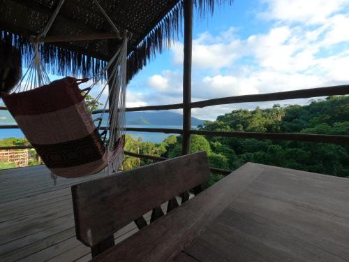 a porch with a hammock and a view of the forest at Villa Girassol in Ilhabela