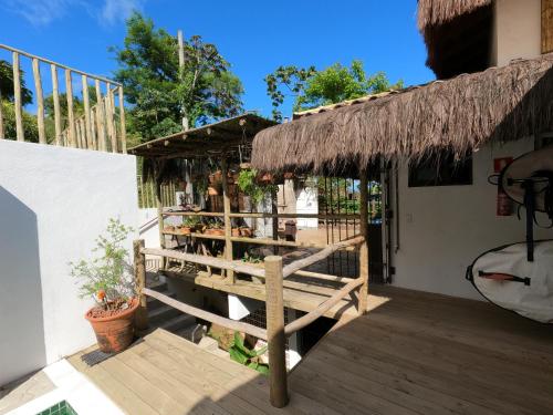 a porch of a house with a thatch roof at Villa Girassol in Ilhabela