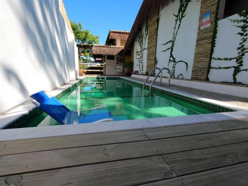a swimming pool with two blue chairs and a swimming pool at Villa Girassol in Ilhabela