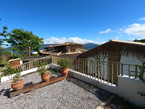 a balcony of a house with potted plants on it at Villa Girassol in Ilhabela