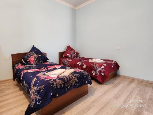 een slaapkamer met 2 bedden en een nachtkastje bij Michael House in Ganja