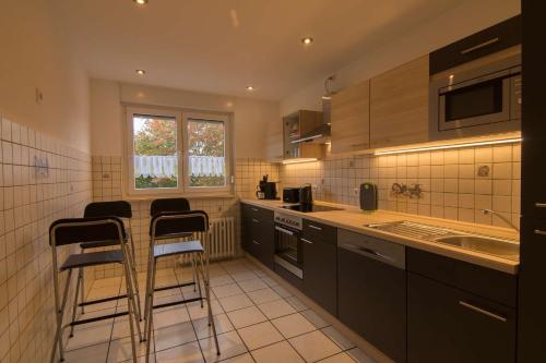 - une cuisine avec une table et des tabourets dans l'établissement Ferienwohnung 'zimmer Frei', à Gelsenkirchen