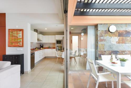 een keuken en eetkamer met een witte tafel en stoelen bij Par 4 Cocoa by VillaGranCanaria in La Playa de Arguineguín