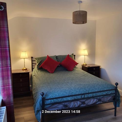 um quarto com uma cama com almofadas vermelhas em Victoria Cottage em Whitby