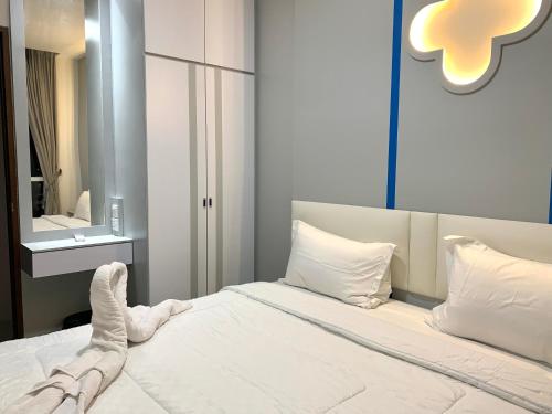 a bedroom with a bed with white sheets and pillows at Wiwi Formosa Residence 2 Bedroom 12-18 in Nagoya