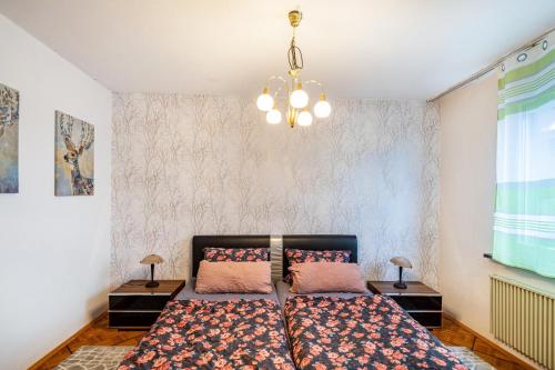 1 dormitorio con 2 camas y lámpara de araña en Traumschmiede, en Bad Emstal