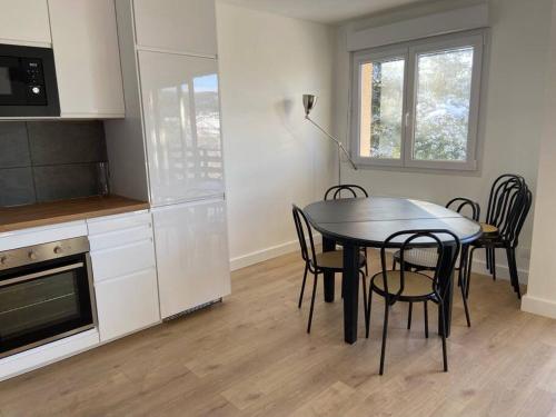 une cuisine avec une table et des chaises dans une pièce dans l'établissement F3 Superbe vue lac, grand balcon, ambiance nature, à Gérardmer