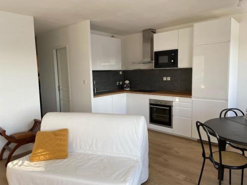 un salon avec un canapé blanc et une table dans l'établissement F3 Superbe vue lac, grand balcon, ambiance nature, à Gérardmer