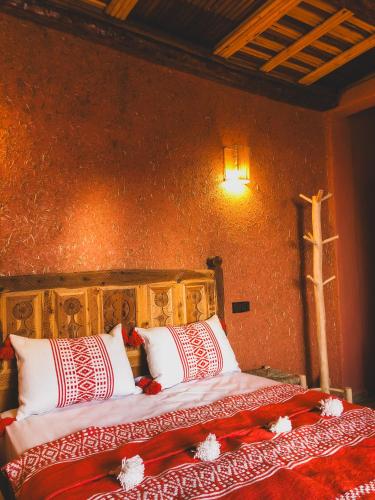 a bedroom with a bed with red and white pillows at Panorama Guesthouse in Agadir