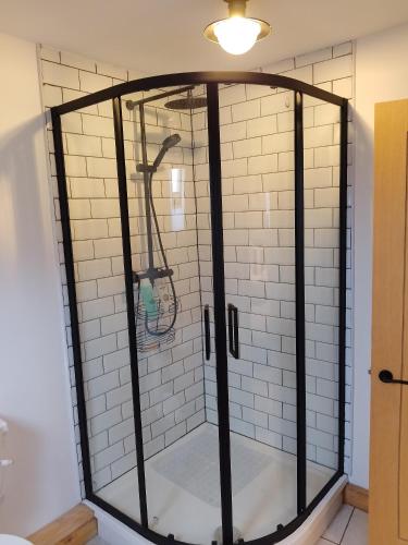 a shower with a glass enclosure in a bathroom at Sanctuary inn in Bolsover