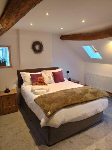 a bedroom with a bed with a teddy bear on it at Sanctuary inn in Bolsover