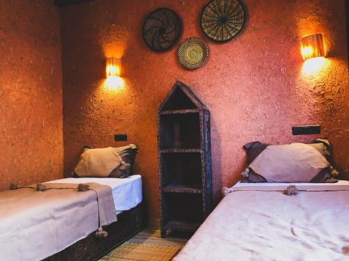 a room with two beds and a wall with clocks at Panorama Guesthouse in Agadir