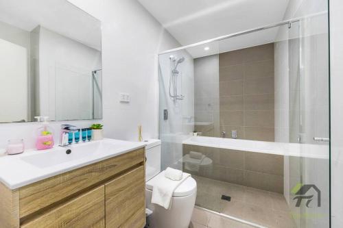 uma casa de banho com um lavatório, um WC e um chuveiro em Sky-City Apt 3 min to Train & Shopping& Everything em Sydney