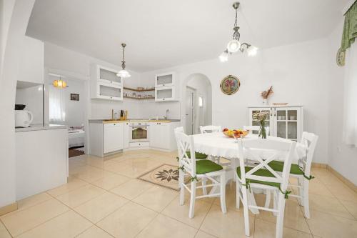 a kitchen and dining room with a white table and chairs at Villa Laura in Medulin for 8 persons only 1.5 km from the beach in Medulin