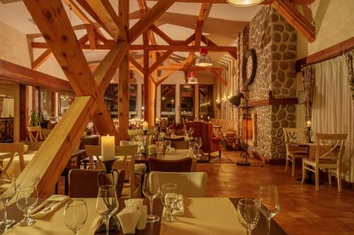 a restaurant with tables and chairs in a room with wooden beams at Green Life Bansko in Bansko
