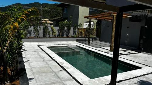 una piscina en medio de un patio en Flat em Juquehy, en São Sebastião