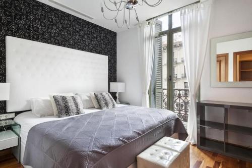 Un dormitorio con una cama grande y una ventana en Canela Homes BARCELONA UNIVERSITAT, en Barcelona