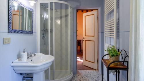 y baño con lavabo y ducha acristalada. en LA MANDOLATA 12, Emma Villas, en Capannori