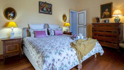 a bedroom with a bed and a dresser at LA MANDOLATA 12, Emma Villas in Capannori