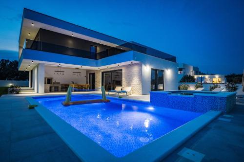 een huis met een zwembad in de nacht bij Villa MaEm in Central Istria for families with Sauna, Whirlpool & Sea View in Juršići