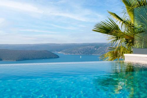 a swimming pool with a view of a lake at Luxury Exclusive Villa Panoramica near Labin - Rabac only 2 km from the beach with sea view and wellness in Koromačno