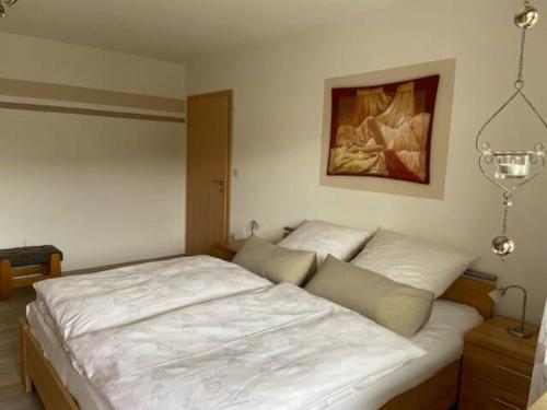 a bedroom with a large bed with white sheets at Haus Boscher in Pappenheim