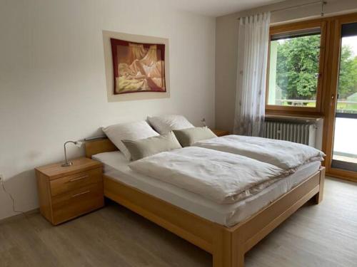 a large bed in a bedroom with a window at Haus Boscher in Pappenheim