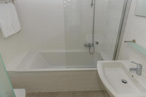 a bathroom with a shower and a tub and a sink at Princesa do Gilão in Tavira