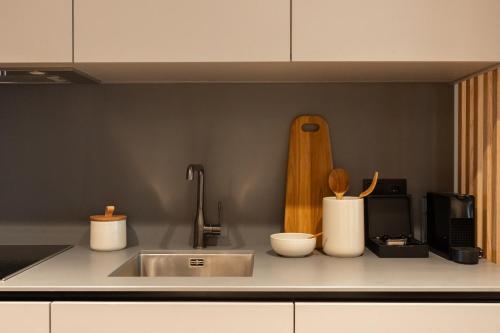 a kitchen counter with a sink and a microwave at Nôma Living Icon Apartments in Porto