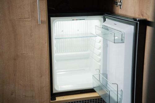 an empty refrigerator with its door open in a kitchen at Frühstückspension Auer - Haus Kargl in Schladming