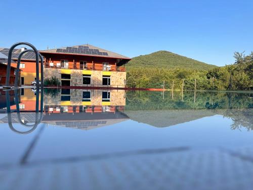 a building sitting on top of a body of water at Szent Orbán Erdei Wellness Hotel és Residence in Kóspallag