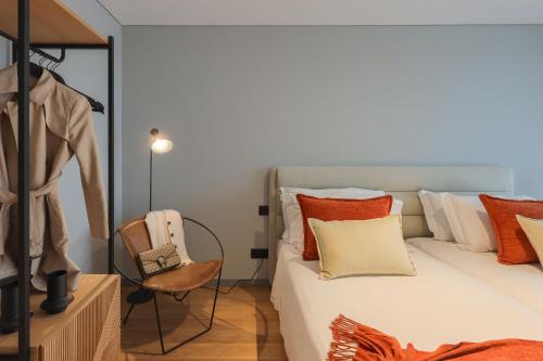 a bedroom with a bed with orange and white pillows at Nôma Living Icon Apartments in Porto