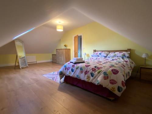 - une chambre mansardée avec un grand lit dans l'établissement Portinaghy House, à Scairbh na gCaorach