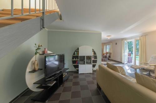 sala de estar con sofá y TV en Träumerei mit Kamin und großzügigem Garten, en Alt Schwerin