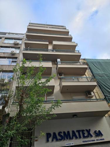 a tall building with a sign on the side of it at Syggrou Open View Apt in Thessaloniki