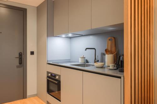 a kitchen with white cabinets and a counter top at Nôma Living Icon Apartments in Porto