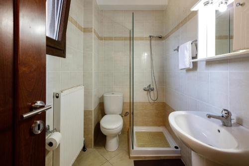 a bathroom with a toilet and a sink and a shower at Villa Rosemary Rethymno in Roussospítion
